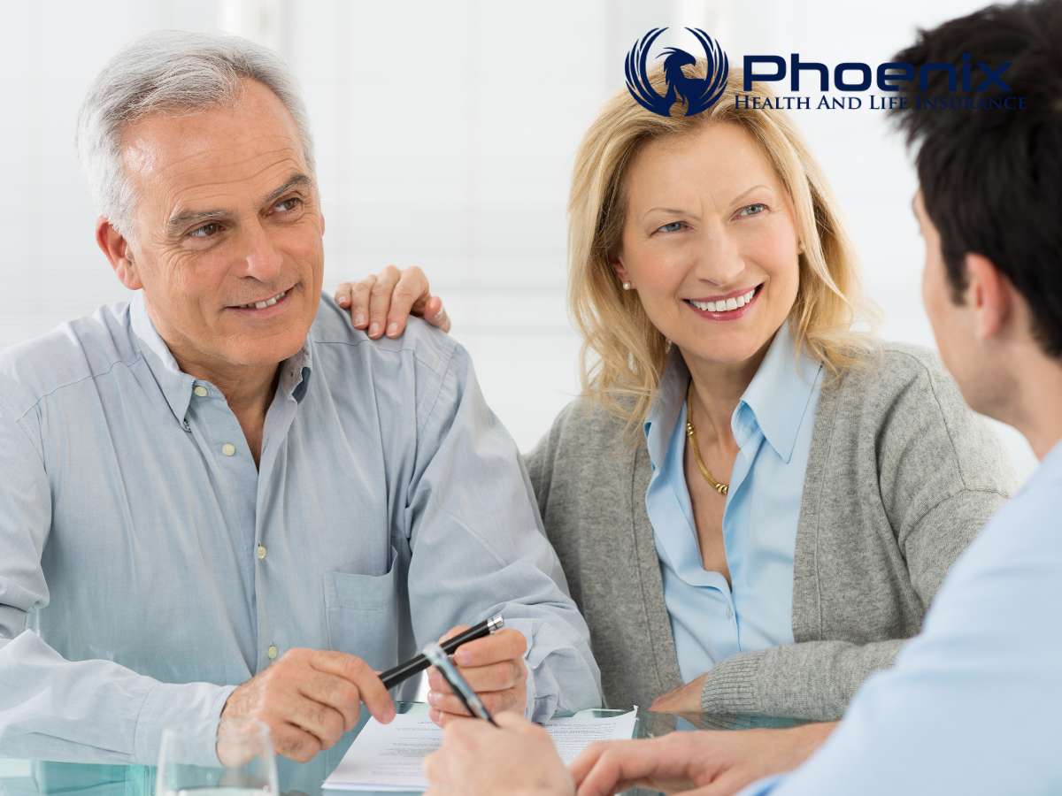 Elderly couple smiling while discussing Healthcare & Insurance with an agent